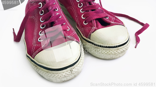 Image of Old crimson sneakers on white background