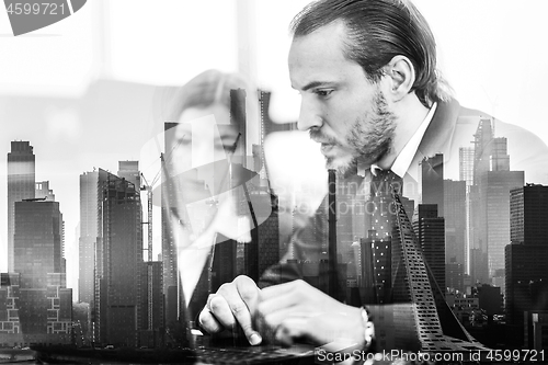 Image of Business people in modern office against new york city manhattan buildings and skyscrapers window reflections.