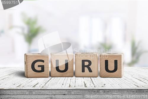 Image of Guru sign on a wooden table in a bright room