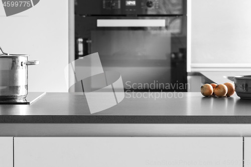 Image of Kitchen table with onions and a pot