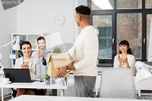 Image of office workers applauding to male colleague