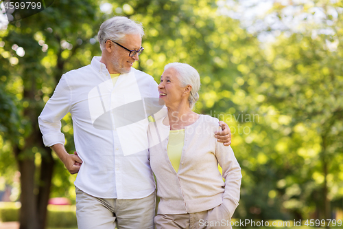 Image of happy senior couple hugging at summer park