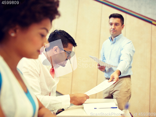 Image of teacher giving tests to students at lecture