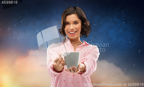 Image of happy young woman in pajama with mug of coffee