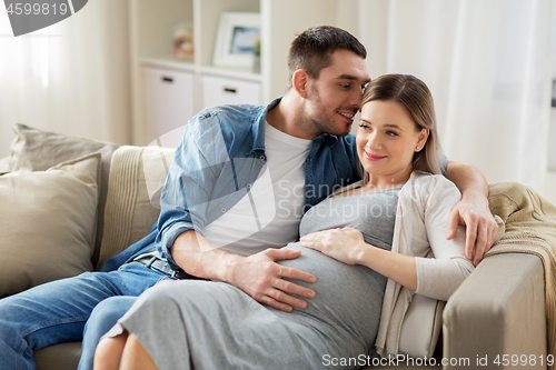 Image of man hugging pregnant woman at home