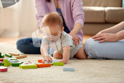 Image of happy family with baby boy playing at home