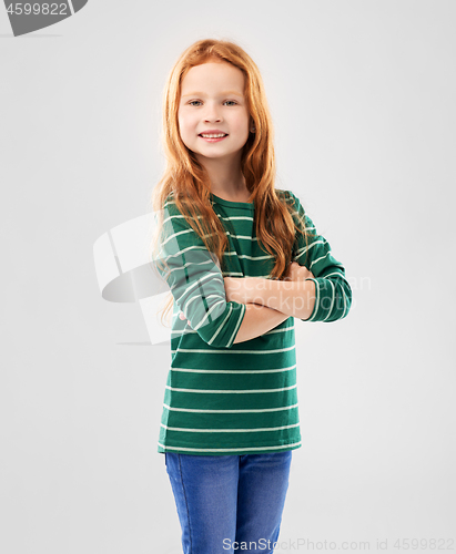 Image of smiling red haired girl posing with crossed arms