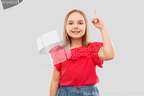 Image of smiling girl in red shirt pointing finger up