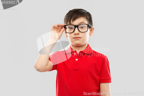 Image of astonished boy in glasses and red t-shirt goggling
