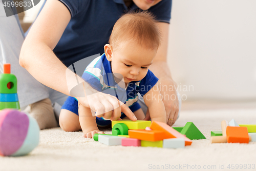 Image of baby boy with father playing toy blocks at home