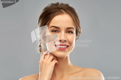 Image of smiling young woman over grey background