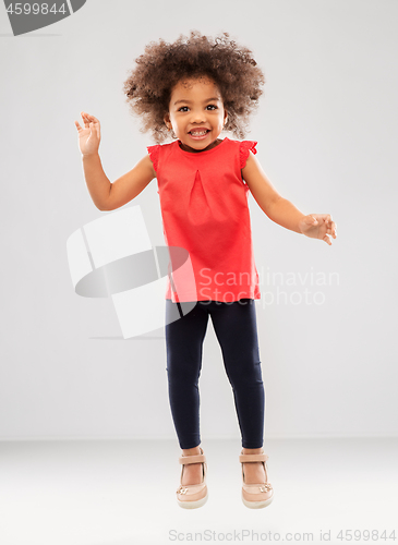 Image of happy little african american girl jumping