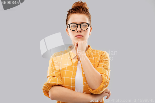 Image of thinking redhead teenage student girl in glasses