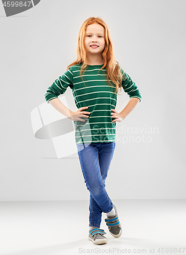 Image of smiling red haired girl posing in striped shirt