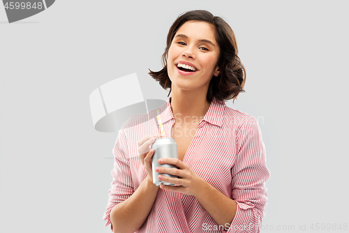 Image of woman drinking soda from can with paper straw