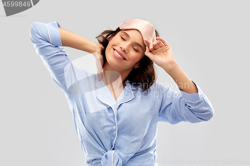 Image of happy young woman in pajama and eye sleeping mask