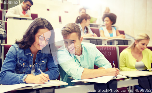 Image of group of students with notebooks at lecture hall