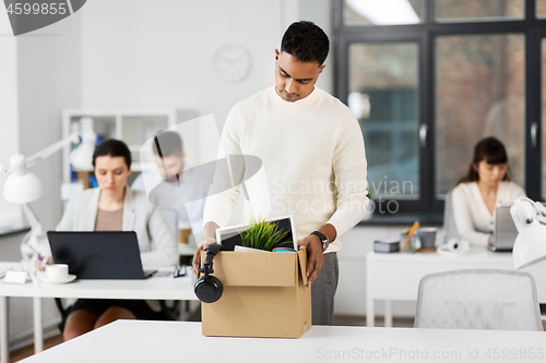 Image of sad fired male office worker with personal stuff