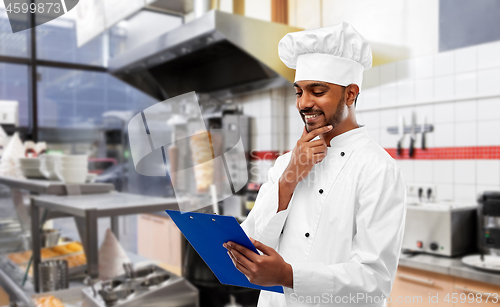 Image of indian chef with menu on clipboard at kebab shop