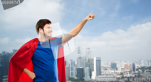 Image of man in red superhero cape over singapore city