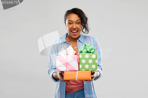 Image of happy african american woman with birthday gifts