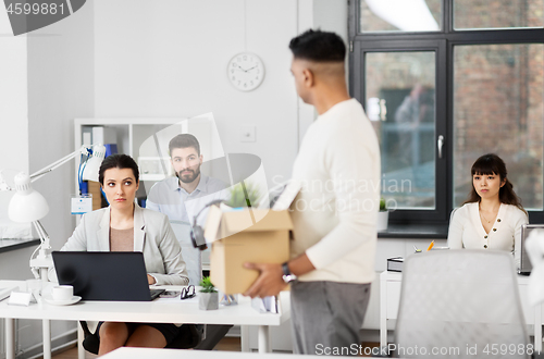 Image of sad office workers looking at fired colleague