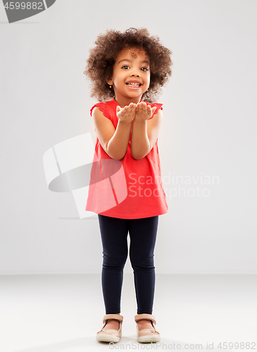 Image of happy african american girl holding something