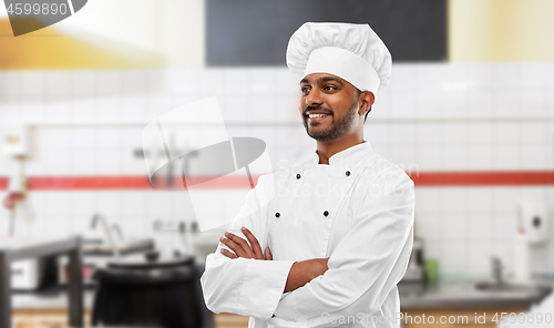 Image of happy indian chef in toque at restaurant kitchen