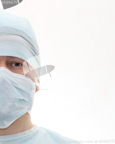 Image of Half face portrait of surgeon in sterile surgical mask and medical cap