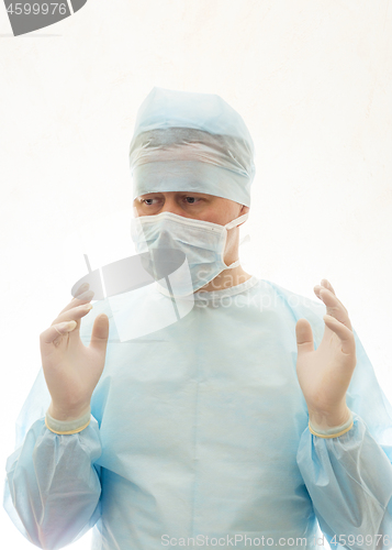 Image of Right positioned hands of ready to work surgeon in sterile gown, mask and gloves