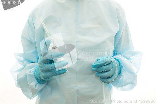 Image of A surgeon in sterile clothing with a syringe is ready to make an injection