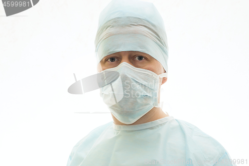 Image of Portrait of calm surgeon in sterile gown and surgical mask