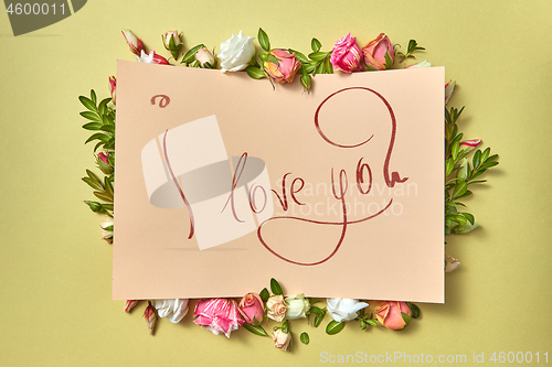 Image of Written text card I love you in the flowers frame.
