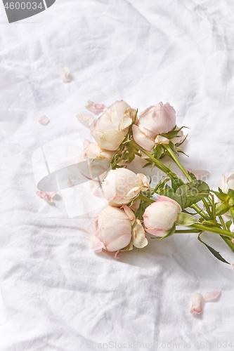 Image of Bouquet of flowers on bed sheets.