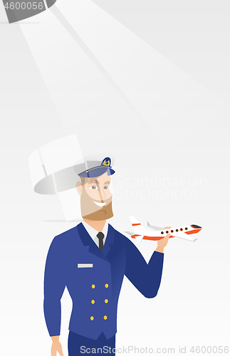 Image of Cheerful airline pilot with the model of airplane.