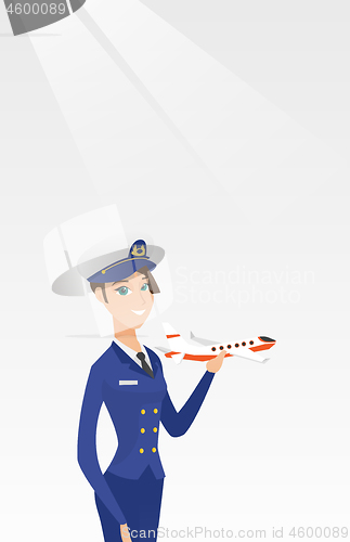 Image of Cheerful airline pilot with the model of airplane.