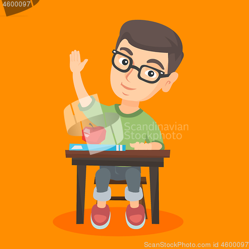 Image of Schoolboy sitting at the desk with raised hand.