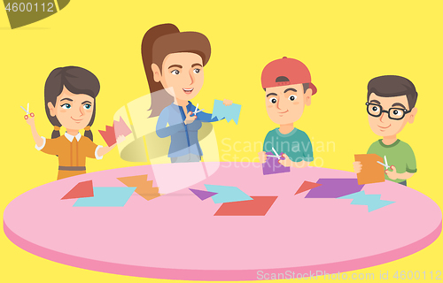 Image of Teacher and children cutting paper with scissors.