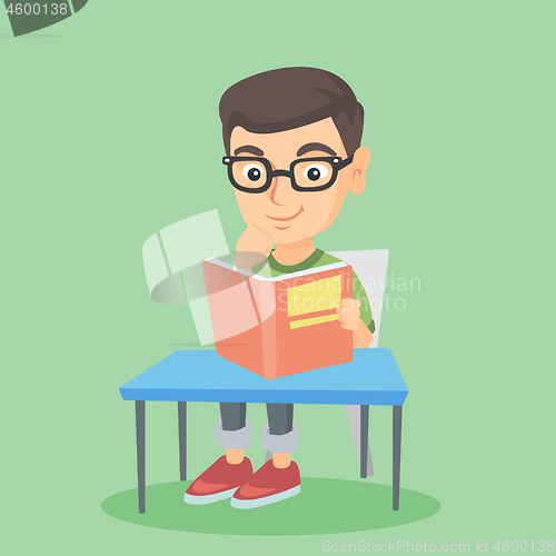 Image of Student sitting at the table and reading a book.