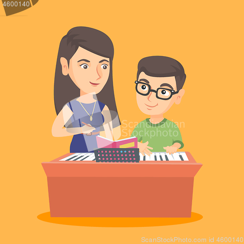 Image of Little boy having a piano lesson with a teacher.