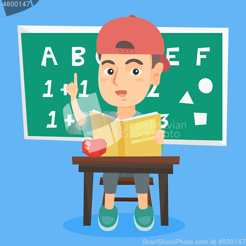 Image of Pupil sitting at the desk and pointing finger up.