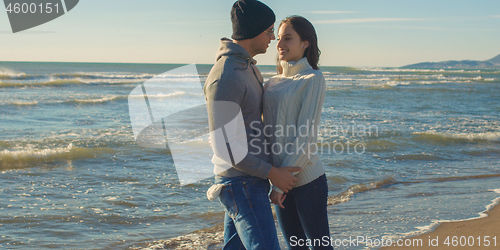 Image of Couple having fun on beautiful autumn day at beach