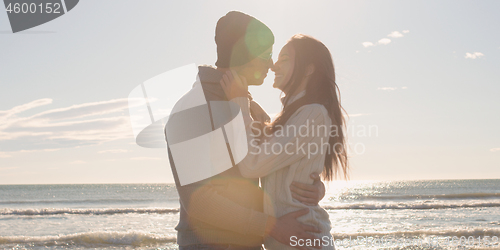 Image of Couple having fun on beautiful autumn day at beach