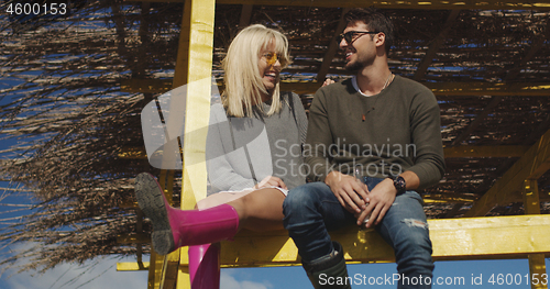 Image of Couple drinking beer together at the beach