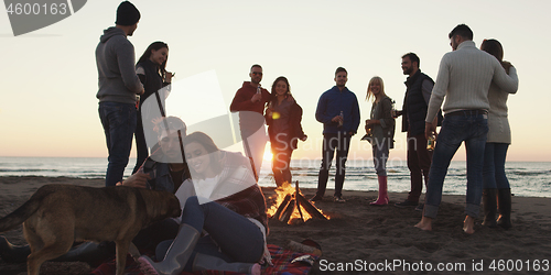 Image of Friends having fun at beach on autumn day