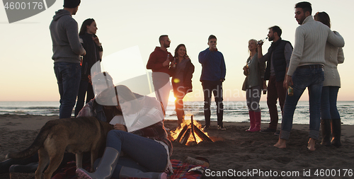 Image of Friends having fun at beach on autumn day