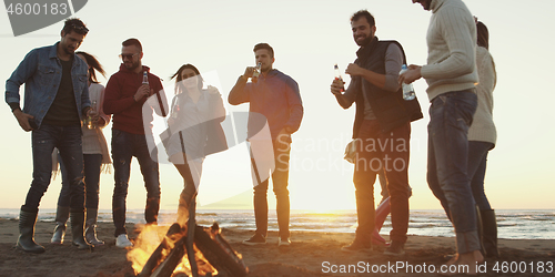 Image of Friends having fun at beach on autumn day