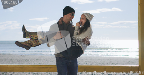 Image of Couple having fun on beautiful autumn day at beach