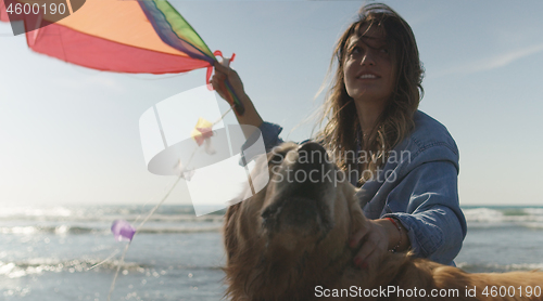 Image of Woman holding kite at beach on autumn day