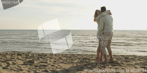 Image of Loving young couple on a beach at autumn on sunny day